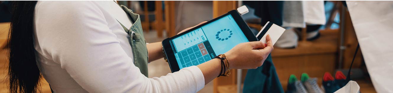 Salesperson swiping a credit card on the tablet point of sales system.