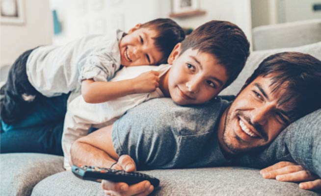 Young family laying on couch in their new home.